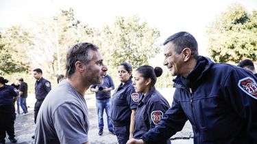 MANO A MANO. Achával saluda a un bombero durante su recorrida por los cuarteles.