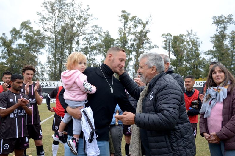 El presidente César Mansilla saluda al Ruso Lara tras entregarle la camiseta. Sus compañeros lo despiden con aplausos.