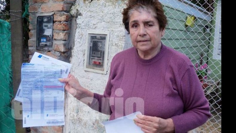 En la puerta de su casa, Mercedes muestra la factura de 3.700 pesos que aún debe..