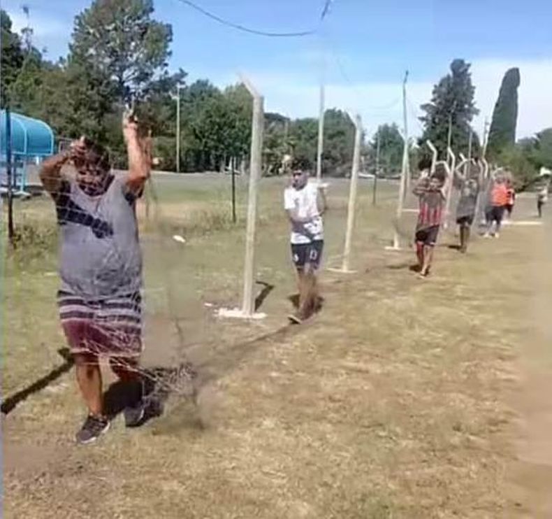 Dirigentes y allegados colocan parte del alambrado olímpico en la cancha de Zelaya.