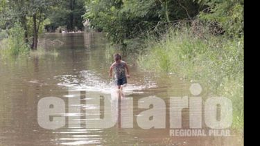 Un chico aprovecha el agua para jugar, sus padres se niegan a dejar su casa..