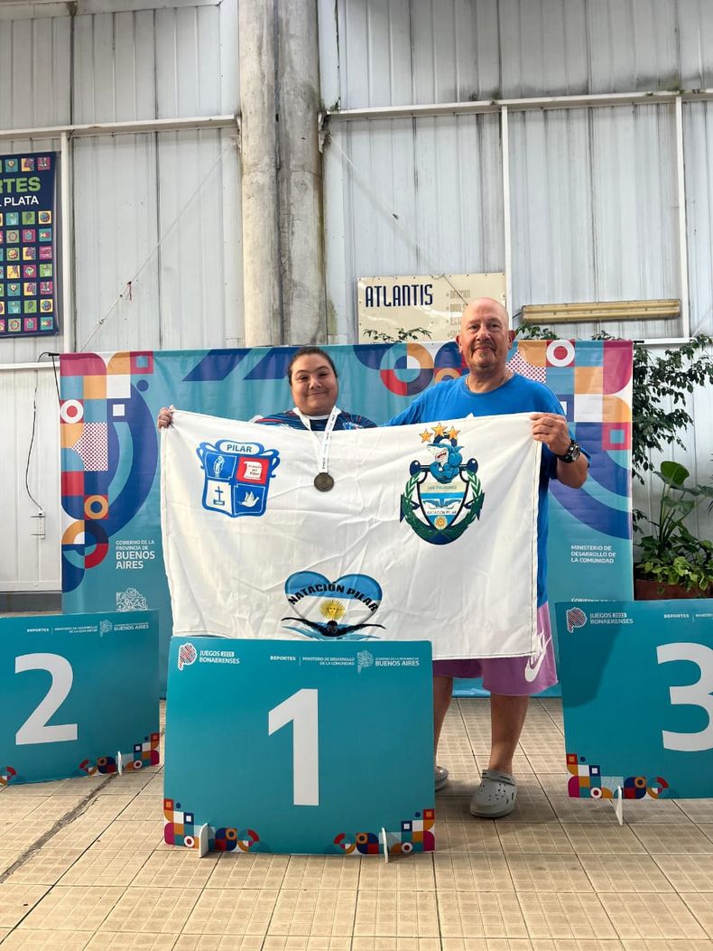 Patricia Aguirre tras ganar el oro en Natación junto a su entrenador.