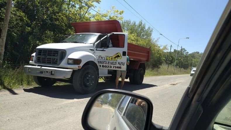 IN FRAGANTI. El camión del corralón Vial Mat fotografiado por vecinos tras volcar su carga en la calle..