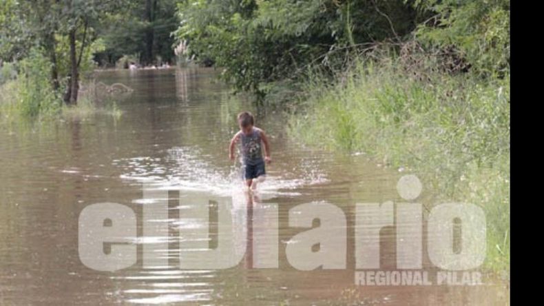 Un chico aprovecha el agua para jugar, sus padres se niegan a dejar su casa..