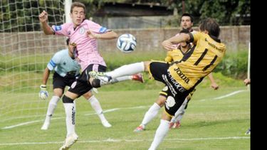 (Heva). Beretta, que jugó su 2º partido en Primera, salta para tapar el tiro de Scamporrino..