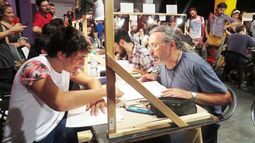 KRIPTO EN EL KONEX. El dibujante de El Diario participó de la 3ª edición de La Noche de los Dibujantes, junto a los más grandes maestros de nuestro país. En las fotos se lo ve dibujando para el público. En la otra imagen, Manu, bailarín de tap de 7 años, feliz con su retrato “estilo Kripto”. .