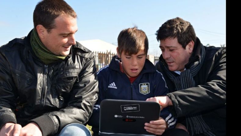 Conectar Igualdad. Santiago Laurent y Mariotto con un chico y su netbook..