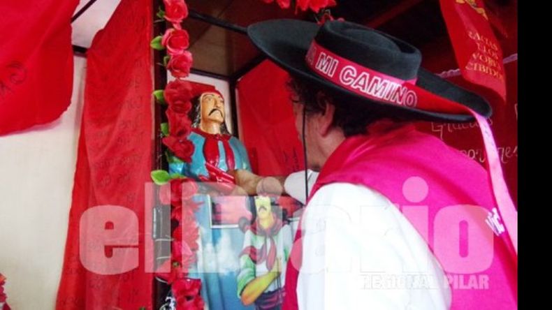 Fe y tradición. Un promesero deja su ofrenda de velas en el santuario de la ruta 25..