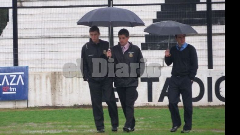 Gastón Iglesias recorre la cancha de Fénix junto a sus asistentes. Después suspendería el partido..