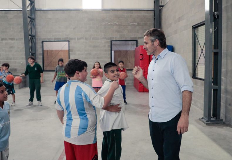 PUÑO. Federico Achával saluda a dos de los chicos que participaron de la actividad.