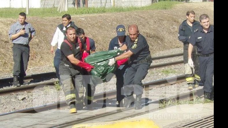 Los bomberos trasladan el cuerpo de la víctima..