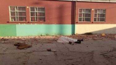 El cuerpo del auxiliar quedó en el patio de la escuela (foto Infobae)..
