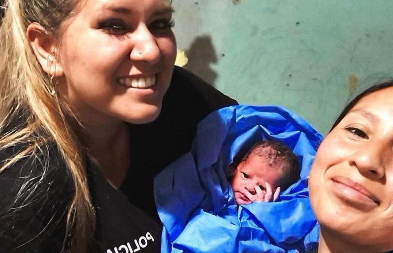Las mujeres policías junto con la beba recién nacida, tras ayudar a su mamá a dar a luz.&nbsp;