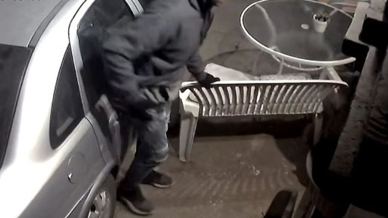 Uno de los delincuentes toma impulso para patear la puerta..