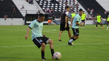 PELOTA. Axel Paiva toca de primera. Detrás Mathías Crocco.
